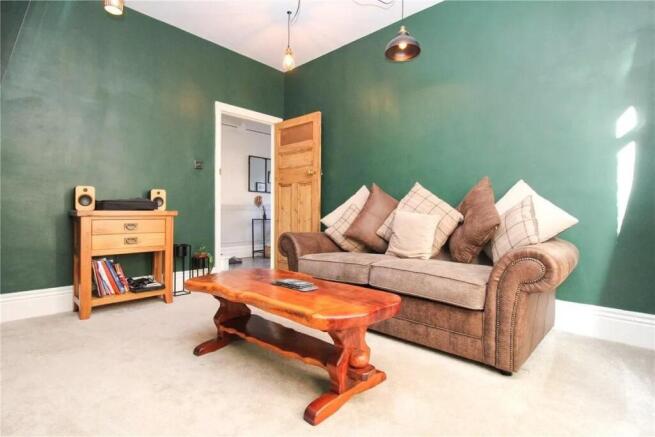 This charming living room features a cozy brown...