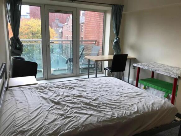 Bright double bedroom featuring a large window ...