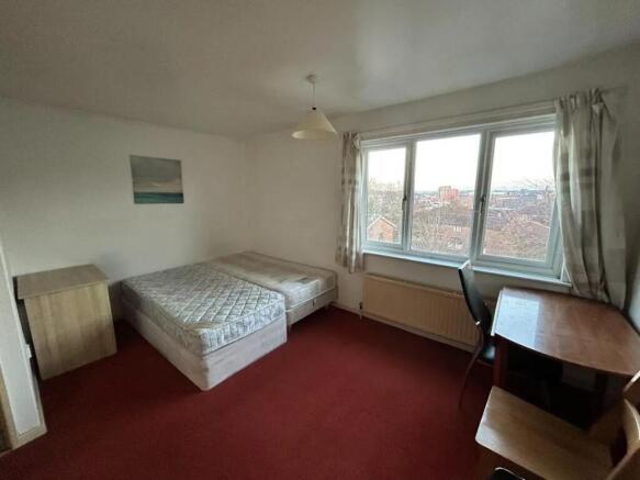 A bright double bedroom featuring a large windo...