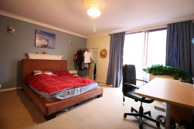 A spacious master bedroom featuring a comfortab...