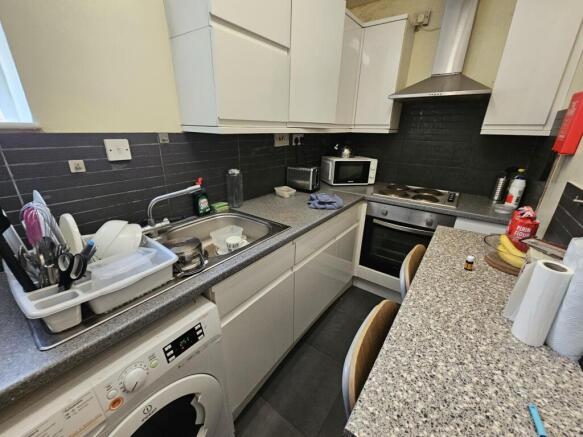 A modern kitchen featuring light cabinetry and ...