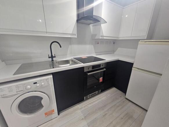 Modern kitchen with sleek black and white cabin...