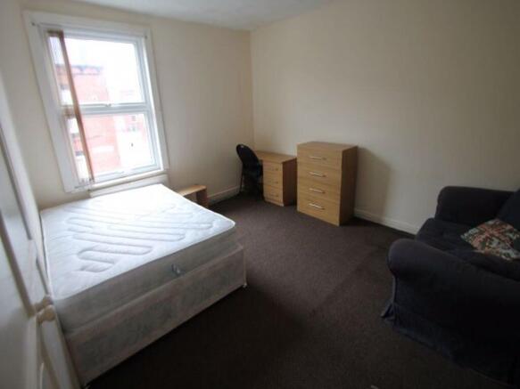 Bright master bedroom featuring a large window ...