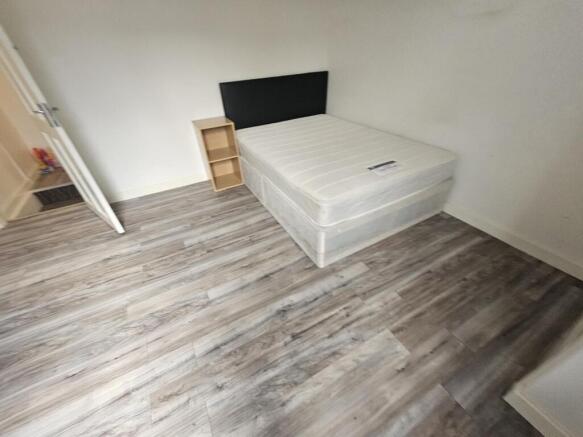 A spacious master bedroom featuring a large bed...