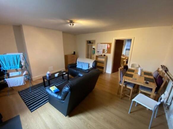 A cozy living room featuring wooden flooring, a...