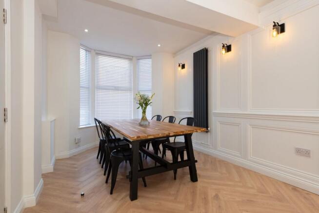 Bright, stylish dining area with a large wooden...
