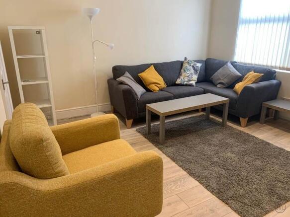 A modern and cozy living room featuring a large...