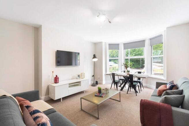 Bright and spacious living room featuring large...