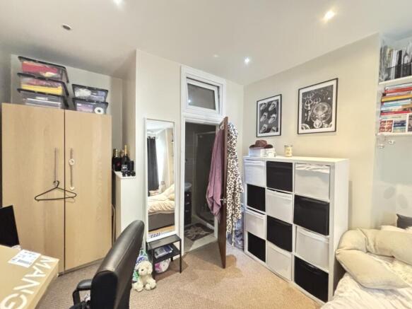 A cozy bedroom featuring a wardrobe, a mirror, ...