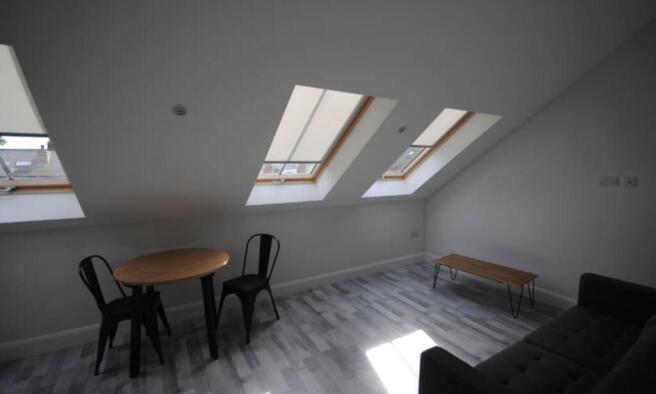 A bright, modern living room with large skyligh...