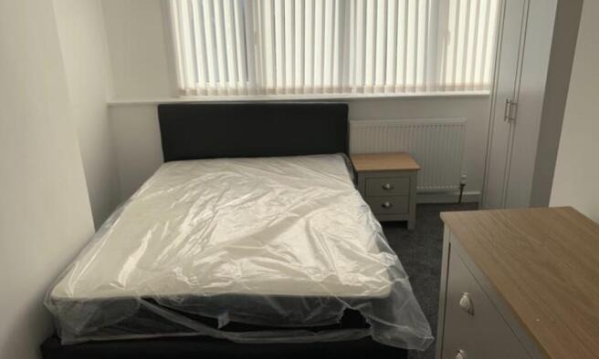 A cozy and well-maintained bedroom featuring a ...