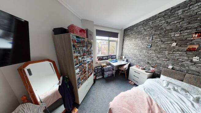 A cozy bedroom with a single bed, a fitted ward...