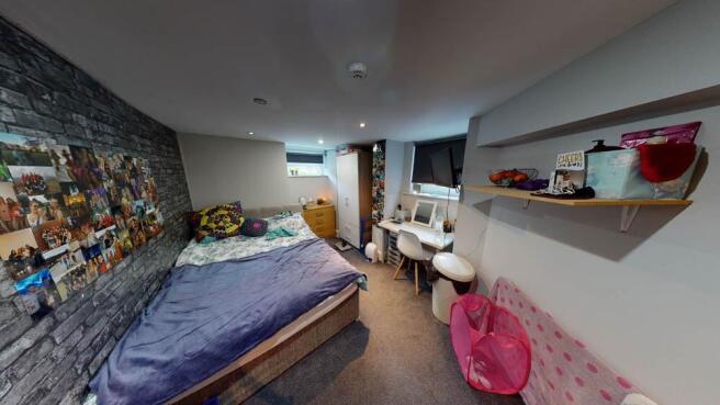 A cozy and well-lit bedroom featuring a spaciou...