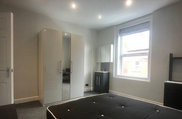 A bright and clean bedroom with a large window ...