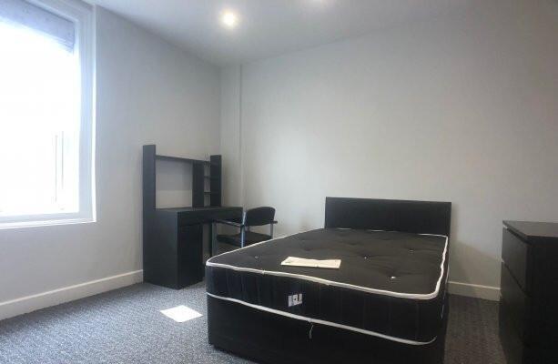 A bright and neat bedroom featuring a comfortab...