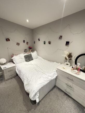 A spacious master bedroom featuring a comfortab...