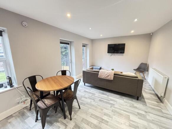 A bright and modern living room featuring large...