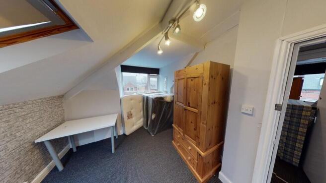 A cozy bedroom featuring a wooden wardrobe, a w...