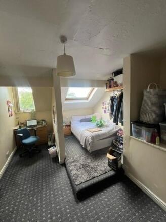 A bright and cozy double bedroom with a sloped ...