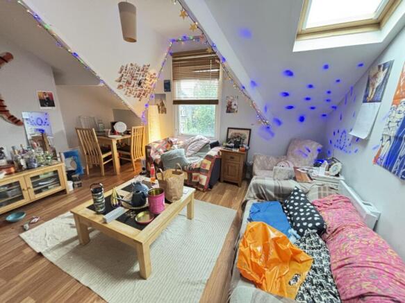 A spacious and well-lit living room featuring m...