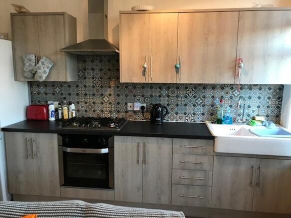 A modern kitchen featuring wooden cabinets, a w...