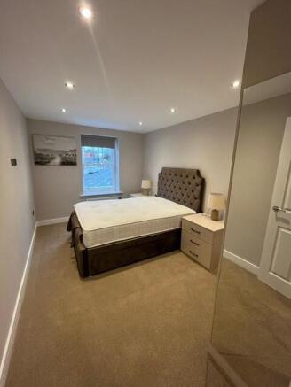 A modern and inviting master bedroom with a lar...
