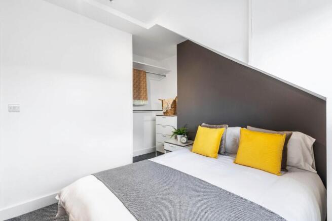 A bright and modern master bedroom featuring a ...