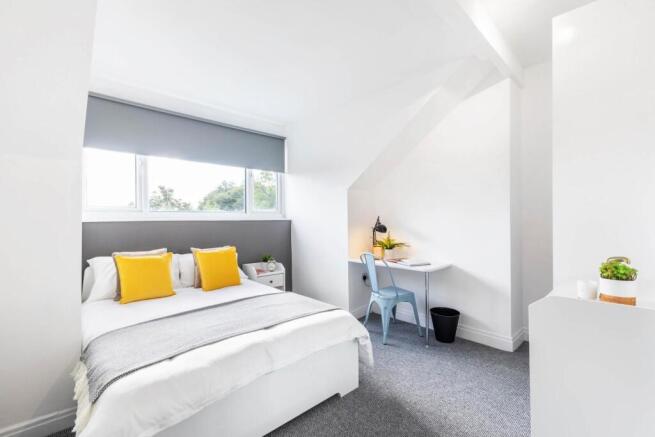 A bright and inviting double bedroom featuring ...
