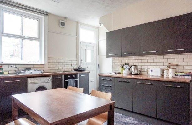 A modern kitchen with ample natural light, feat...
