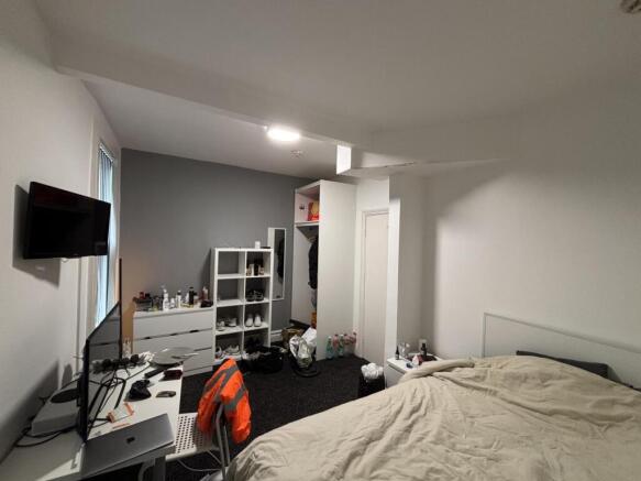 A cozy bedroom featuring a neatly made bed, a s...