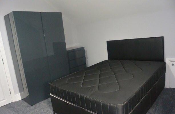 A spacious master bedroom featuring a large bed...