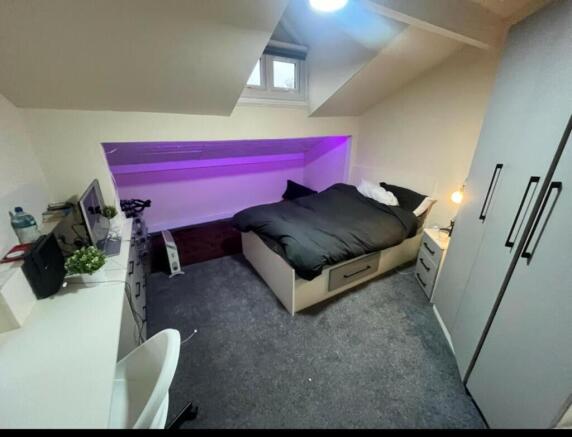 A spacious, well-lit master bedroom featuring a...