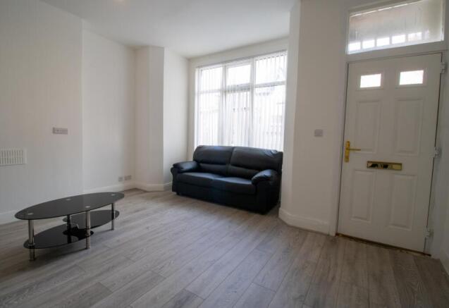 A bright, spacious living room featuring a comf...