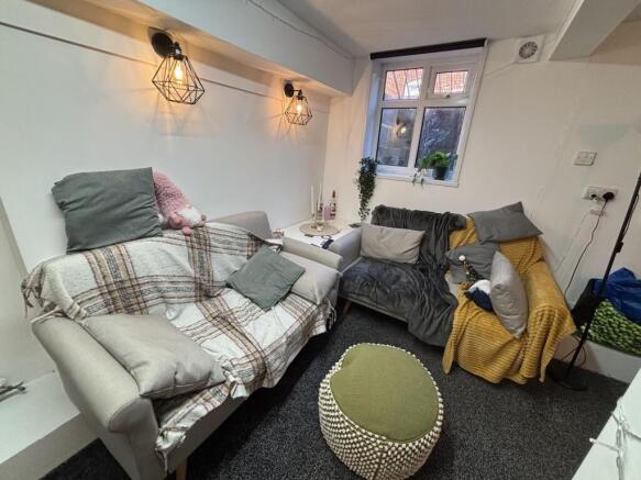 A cozy and well-lit living room featuring comfo...