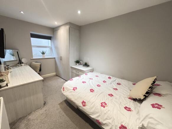 A clean and well-lit bedroom featuring a double...