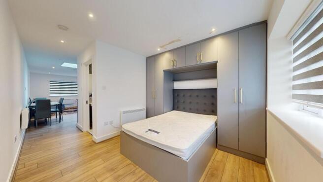 Bright, modern bedroom with integrated grey fit...