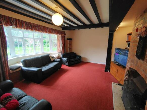 Bright living room with a large bay window look...