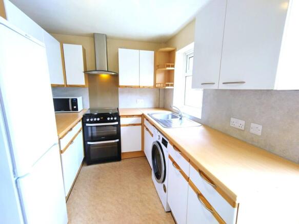 Bright modern kitchen with light wood counterto...