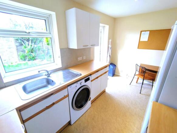 Bright galley-style kitchen with a large window...