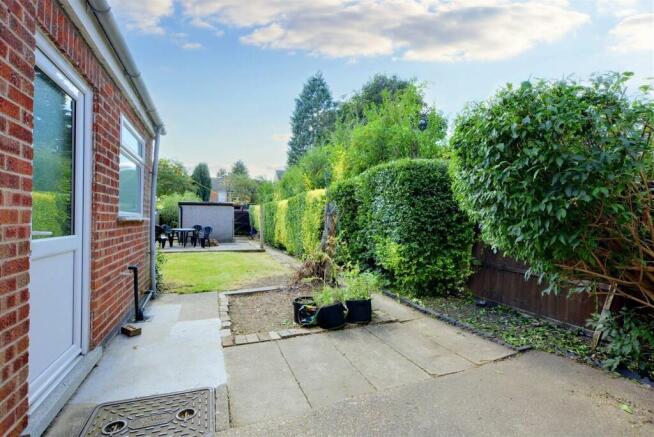 Well-maintained rear garden with a paved patio,...