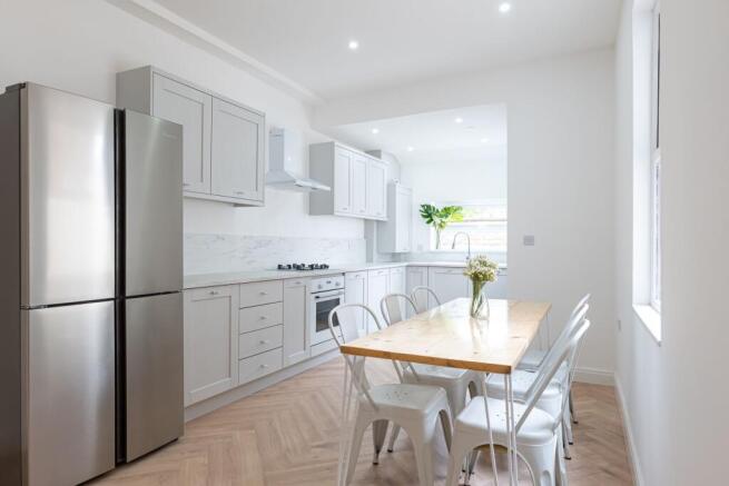 Bright, modern kitchen with pale shaker cabinet...