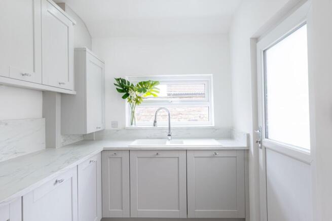 Bright, modern kitchen with light grey cabinetr...