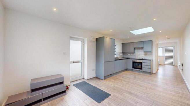 Bright open-plan kitchen with modern fitted uni...