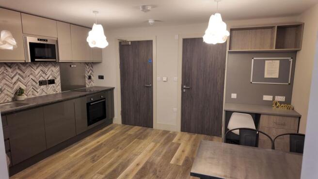 Modern open-plan kitchen area with sleek grey c...