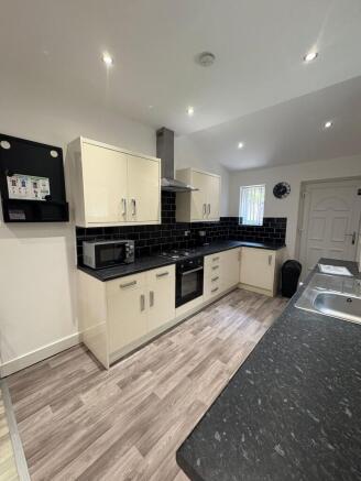 Bright, modern kitchen with cream gloss cabinet...
