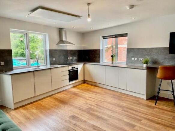Bright modern kitchen with L-shaped white cabin...