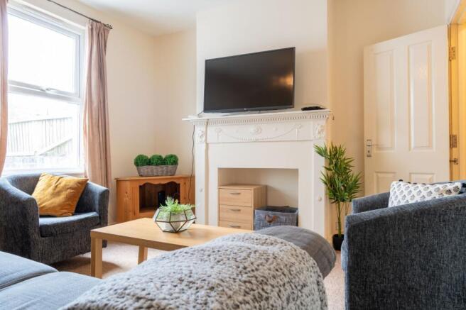 Bright, neatly furnished living room with comfo...