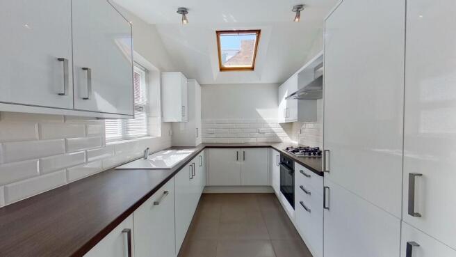 Contemporary galley kitchen with glossy white c...