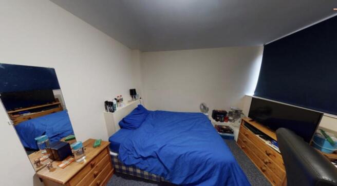 A well-kept bedroom featuring a double bed with...