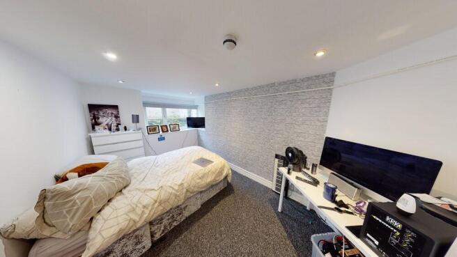 A spacious and well-lit master bedroom featurin...